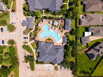 A bird's eye view of a neighborhood with a swimming pool in the center.